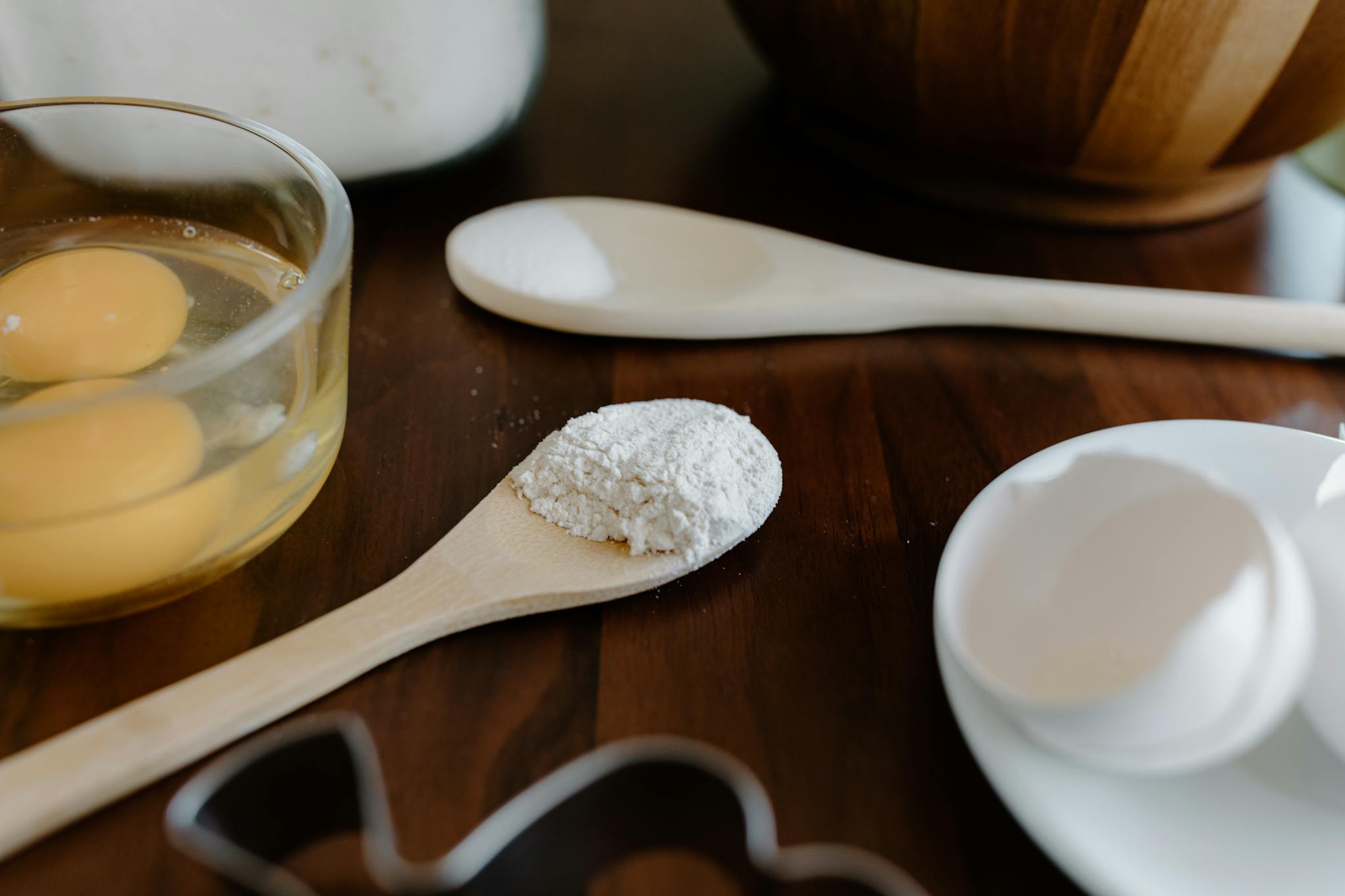 Close-up view of eggs, flour, and utensils ready for baking preparation.